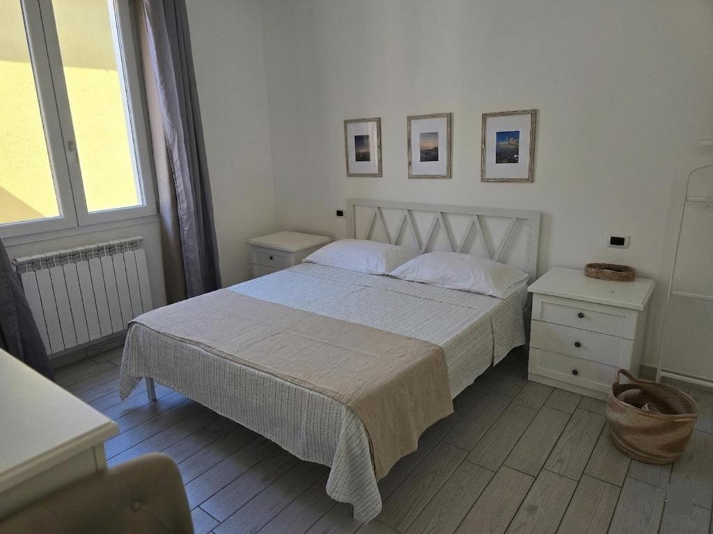a bedroom with a bed and two tables and a window at camera vicino a mare e pineta in Follonica