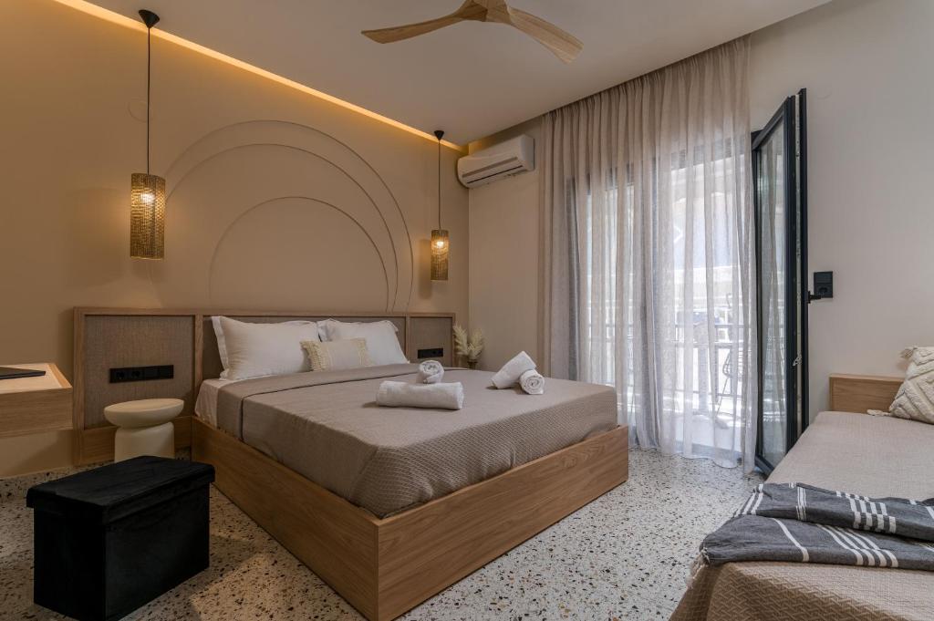 a bedroom with two beds and a large window at Six Doors in Pefkochori