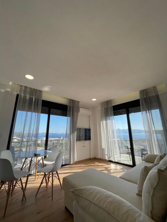 a living room with a couch and a table with chairs at Azzurre Premium Aparthotel in Sarandë