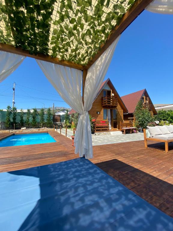 a tent on a deck with a swimming pool at Berat Wooden Villas with Private Pool in Berat