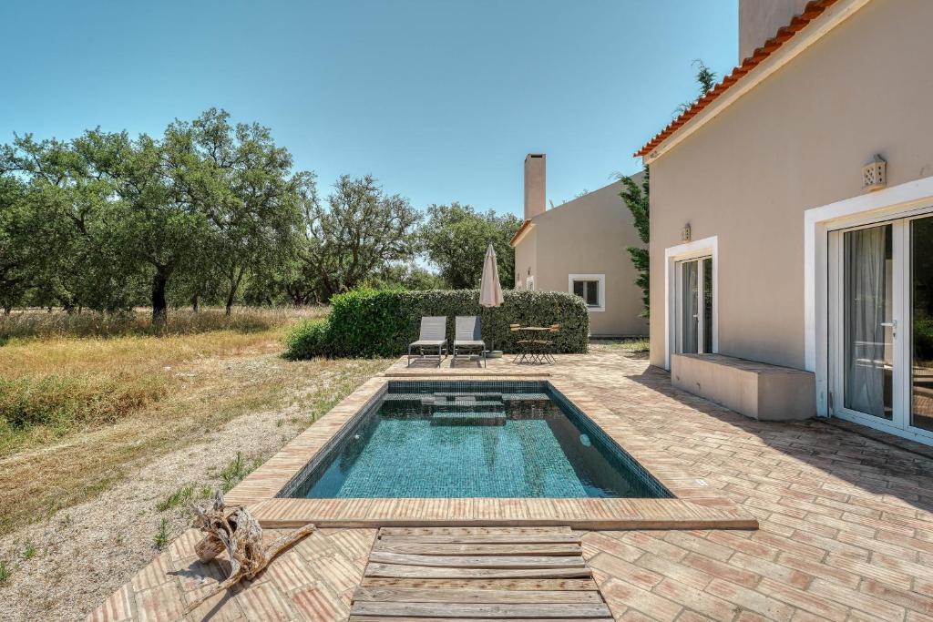 a swimming pool in the backyard of a house at The Pink Stork Villa in Alcácer do Sal