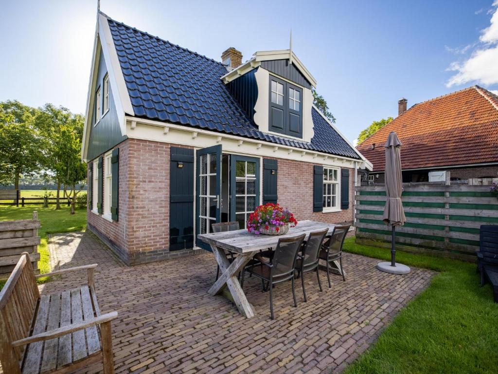 a patio with a table and chairs and a house at Limosa in Hippolytushoef
