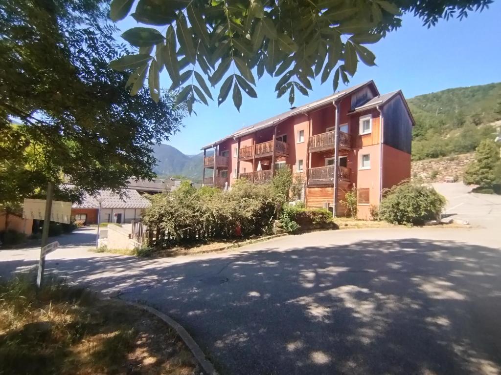 an apartment building with a tree in the foreground at location Ax les Thermes in Ax-les-Thermes