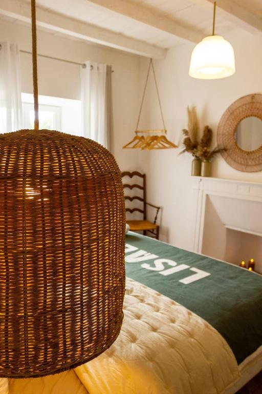 a wicker basket hanging over a bed in a room at Gites Lisael et le 1808 proches Puy DuFou in Mauléon