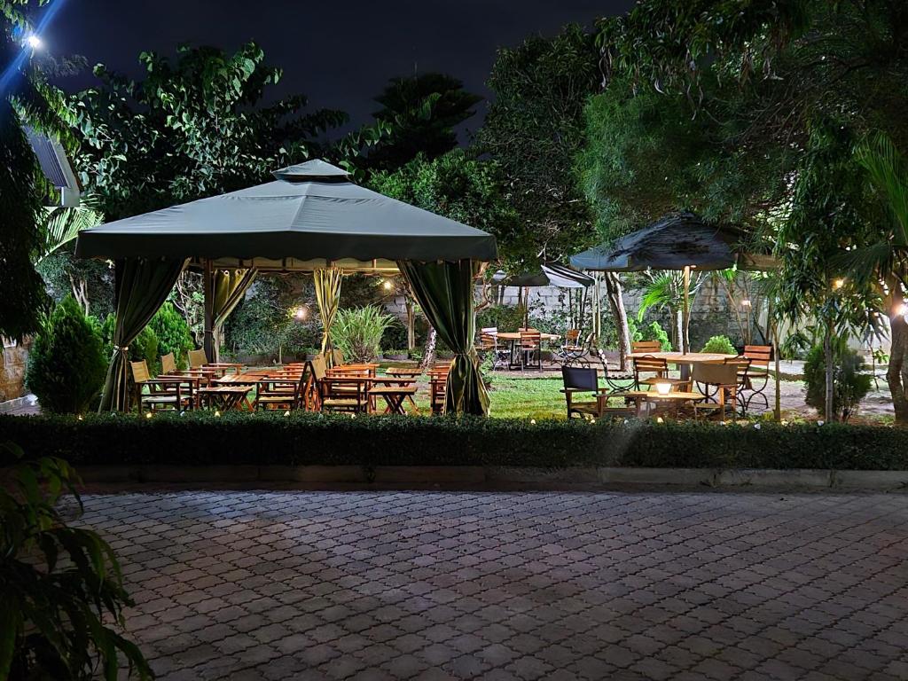 a patio with tables and umbrellas at night at Teresita Home JKIA in Nairobi