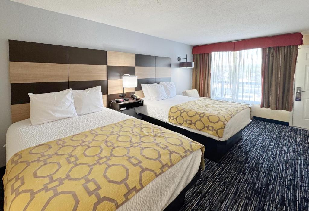 a hotel room with two beds and a window at Baymont by Wyndham Sevierville Pigeon Forge in Sevierville