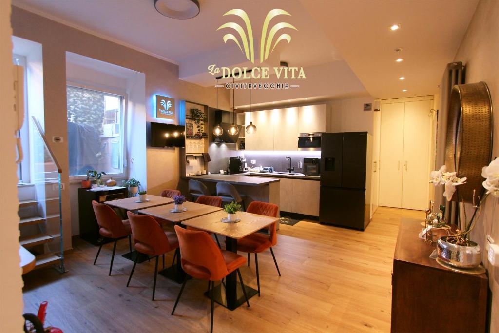 a restaurant with a table and chairs and a kitchen at La Dolce Vita Civitavecchia in Civitavecchia
