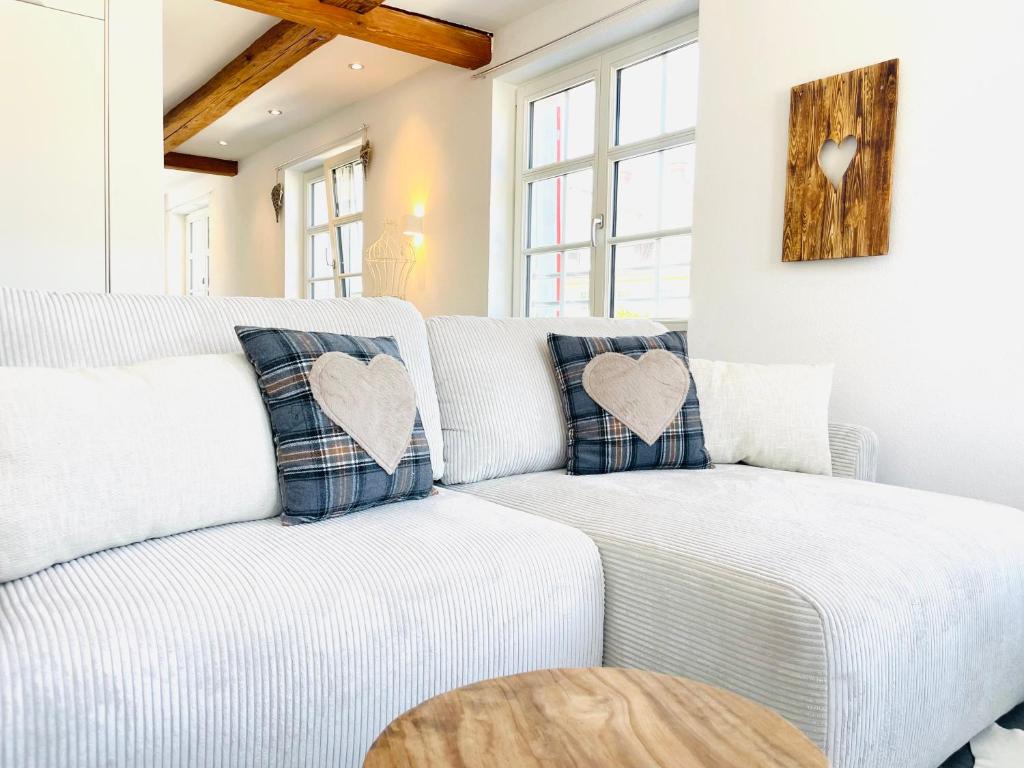 a living room with a white couch with heart pillows at Appartement "Loft Seeliebe" in Kreuzlingen