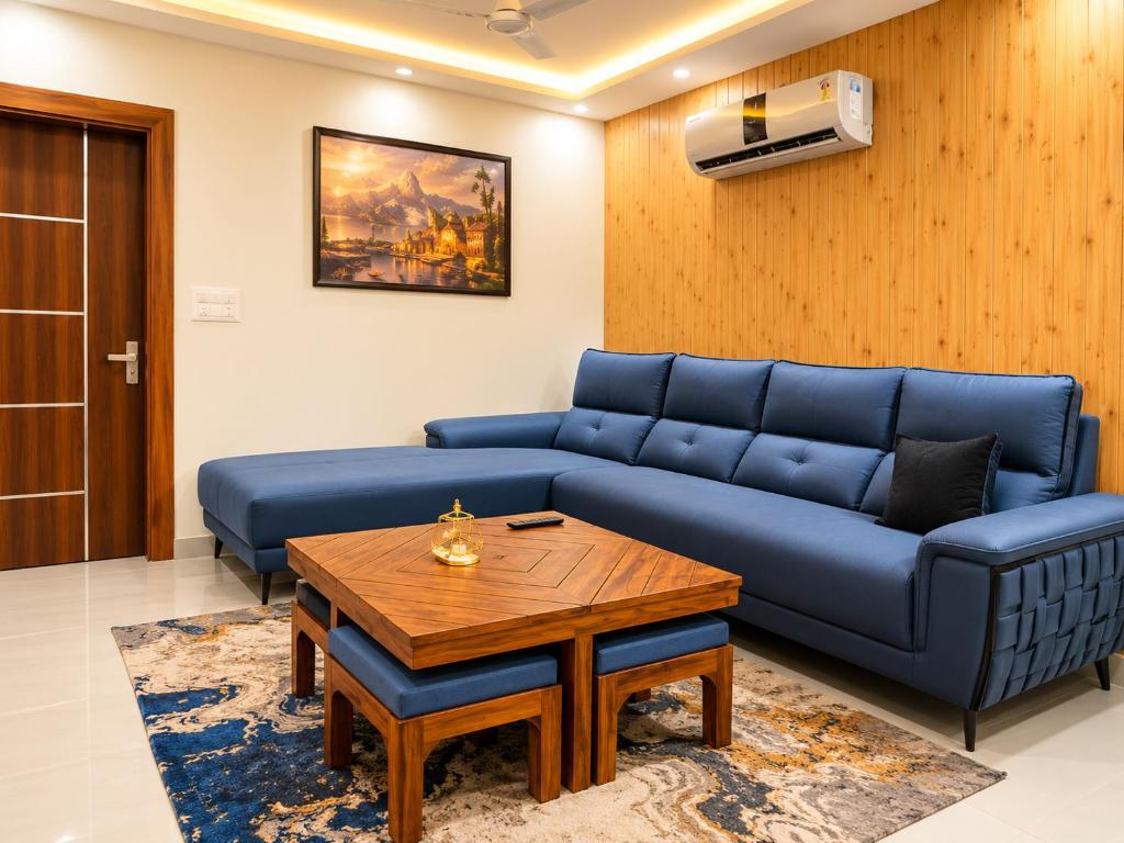a living room with a blue couch and a table at The Elite Luxury Suite in Dehradun