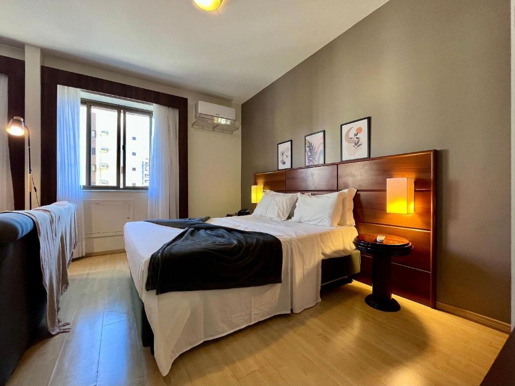a hotel room with a large bed and a window at Studio apartment in downtown Joinville, SC in Joinville