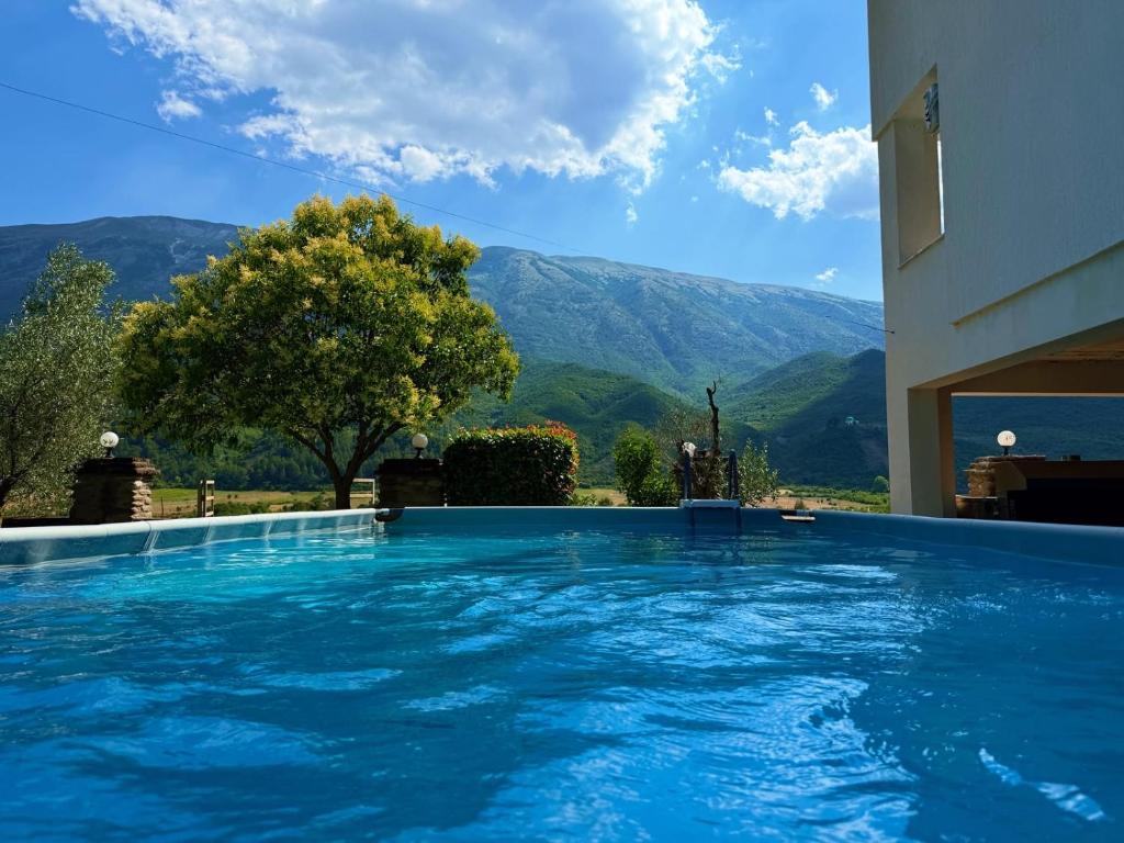 a swimming pool with a view of mountains at Kutal Park Inn Hotel in Përmet