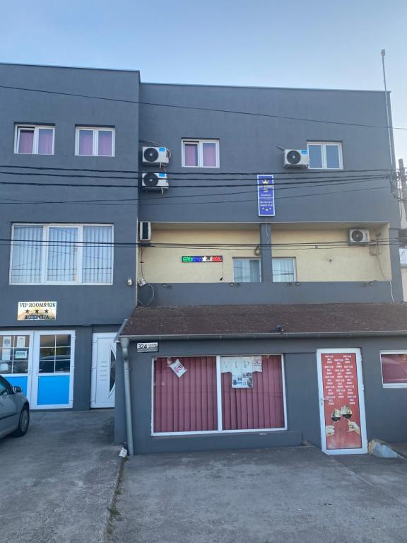a building with a red door in a parking lot at ViP ROOMS PRENOCISTE 026 in Smederevo