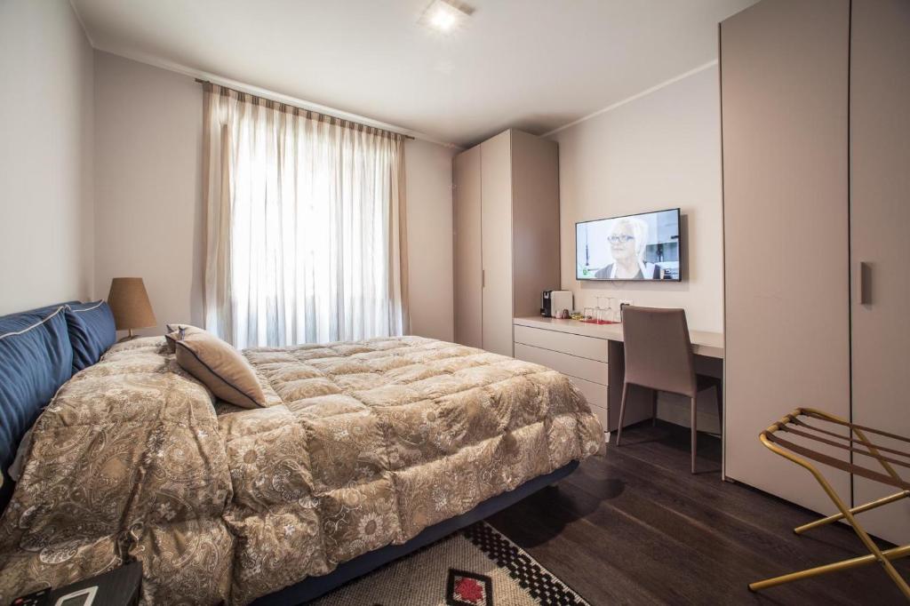 a bedroom with a bed and a desk and a television at Il Regio Maison di Charme in Cagliari