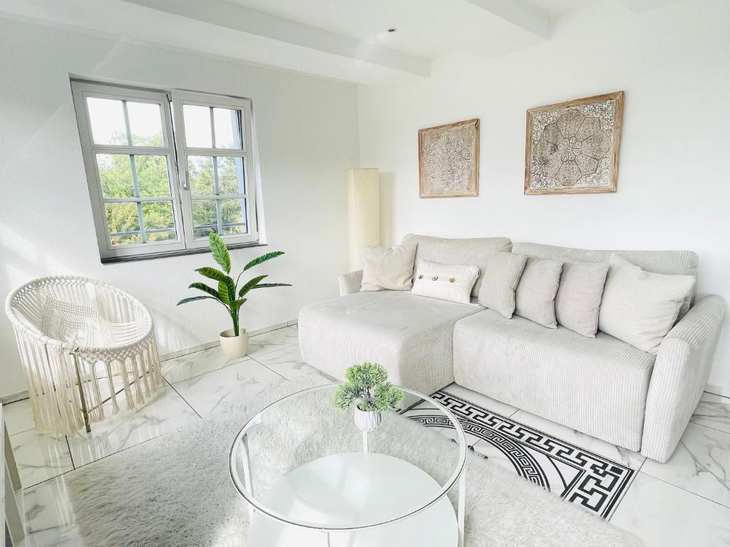 a white living room with a couch and a table at Appartement "Hörnli Seeliebe" in Kreuzlingen
