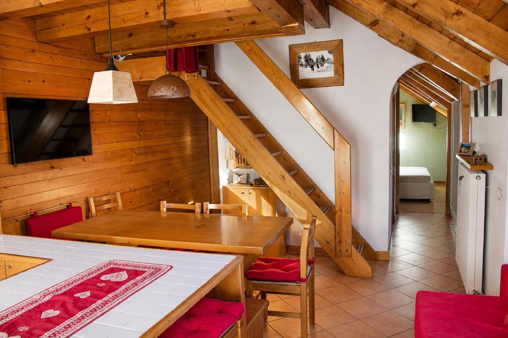 a kitchen and dining room with a table and a staircase at Appartamento Belvedere in Asiago