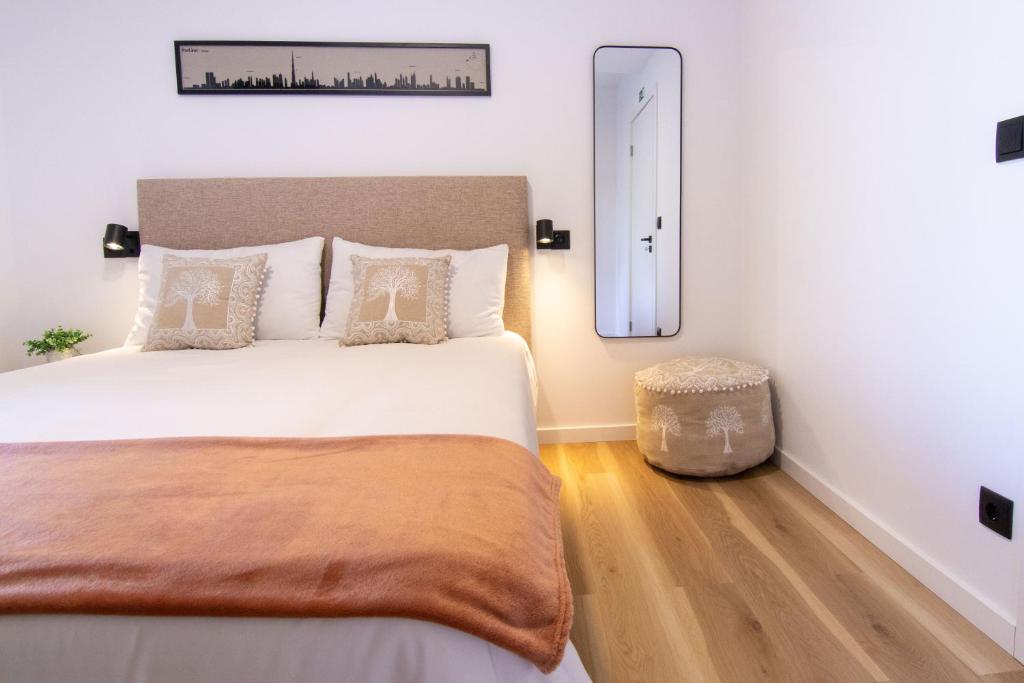 a bedroom with a large bed and a mirror at Latitude Guest House in Cantanhede