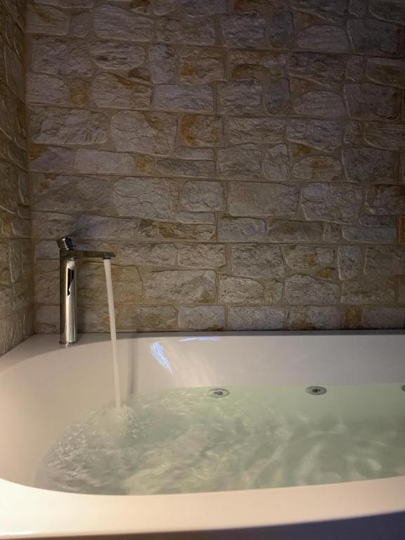 a bath tub filled with water with a faucet at Maiori Vacation Home in Cinisi