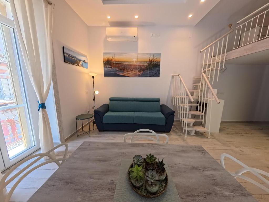 a living room with a blue couch and stairs at La casa di venera in Bacoli