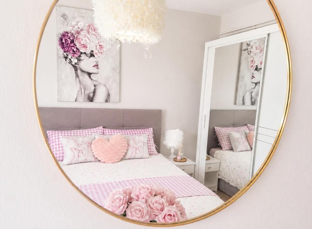 a bedroom with a bed with pink pillows and a mirror at Nina in Baška Voda