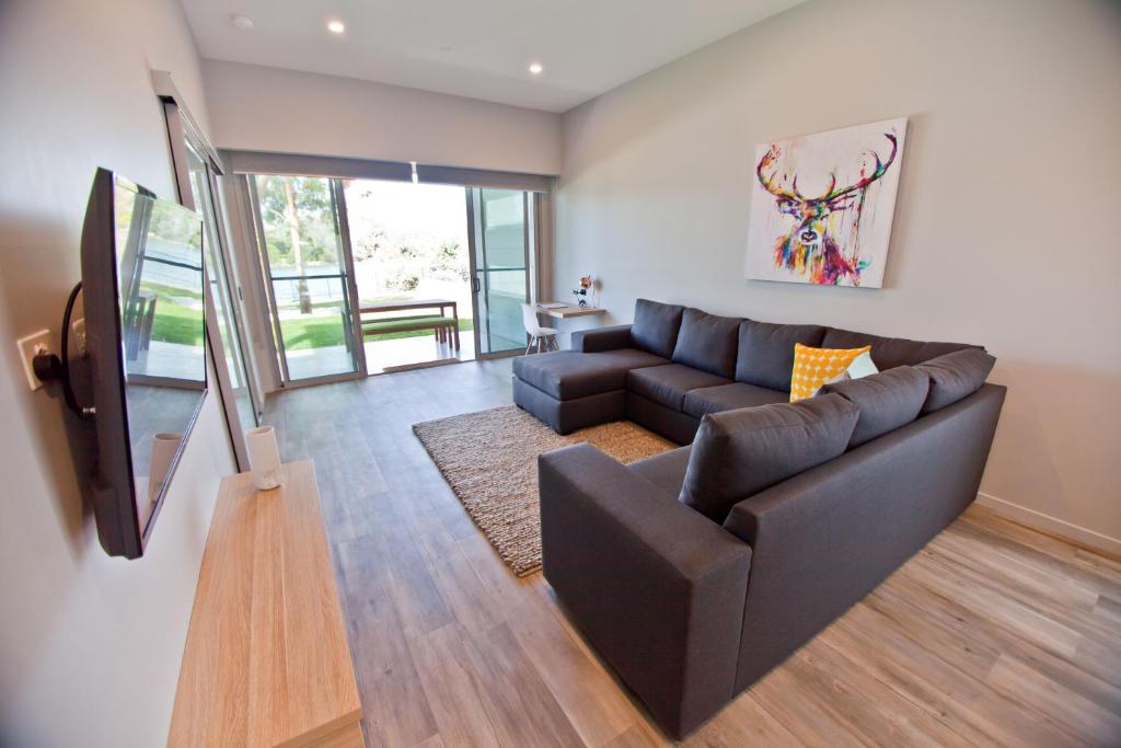 a living room with a couch, coffee table and a television at Waterfront Apartments in Devonport