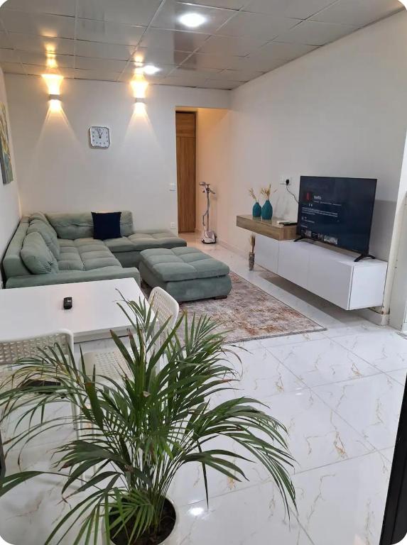 a living room with a couch and a tv at إقامة مريحة وممتعة في شارع الاميرات in Baghdād
