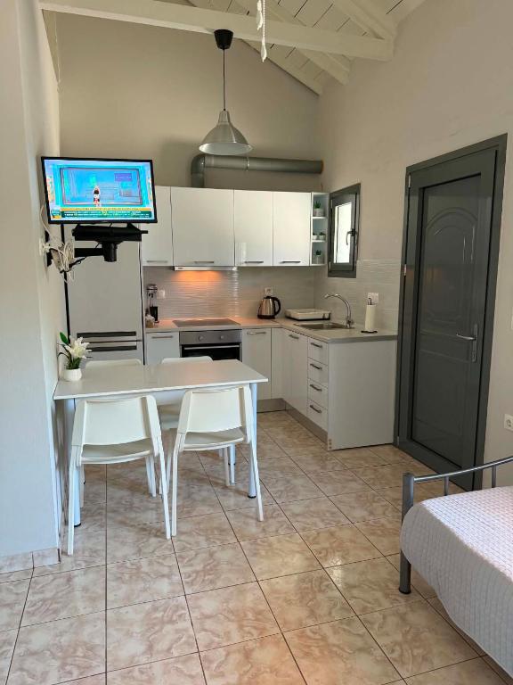 a kitchen with a white table and white cabinets at George's place in Plytra