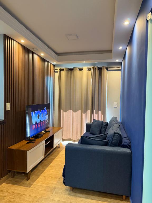 a bedroom with a blue bed and a tv at Flat Red Sorocaba - Blue in Sorocaba