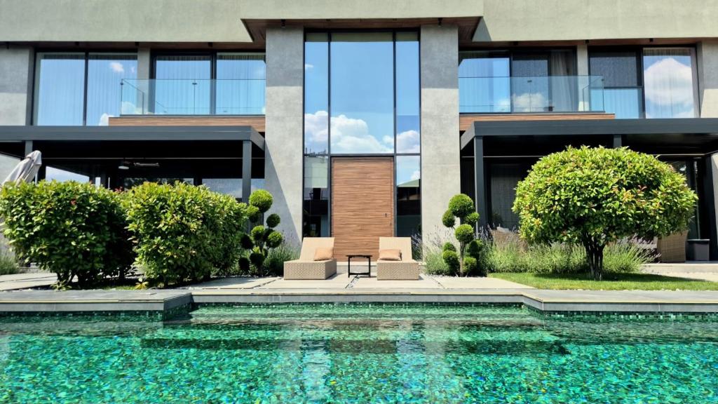 a house with a swimming pool in front of a building at Diwine Spa House Fruška Gora in Irig
