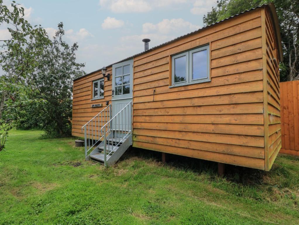 a tiny house with a staircase in a yard at Bramleys in Taunton