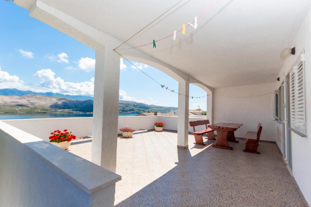 a balcony with a table and a view of the water at Apartmants 38 in Pag
