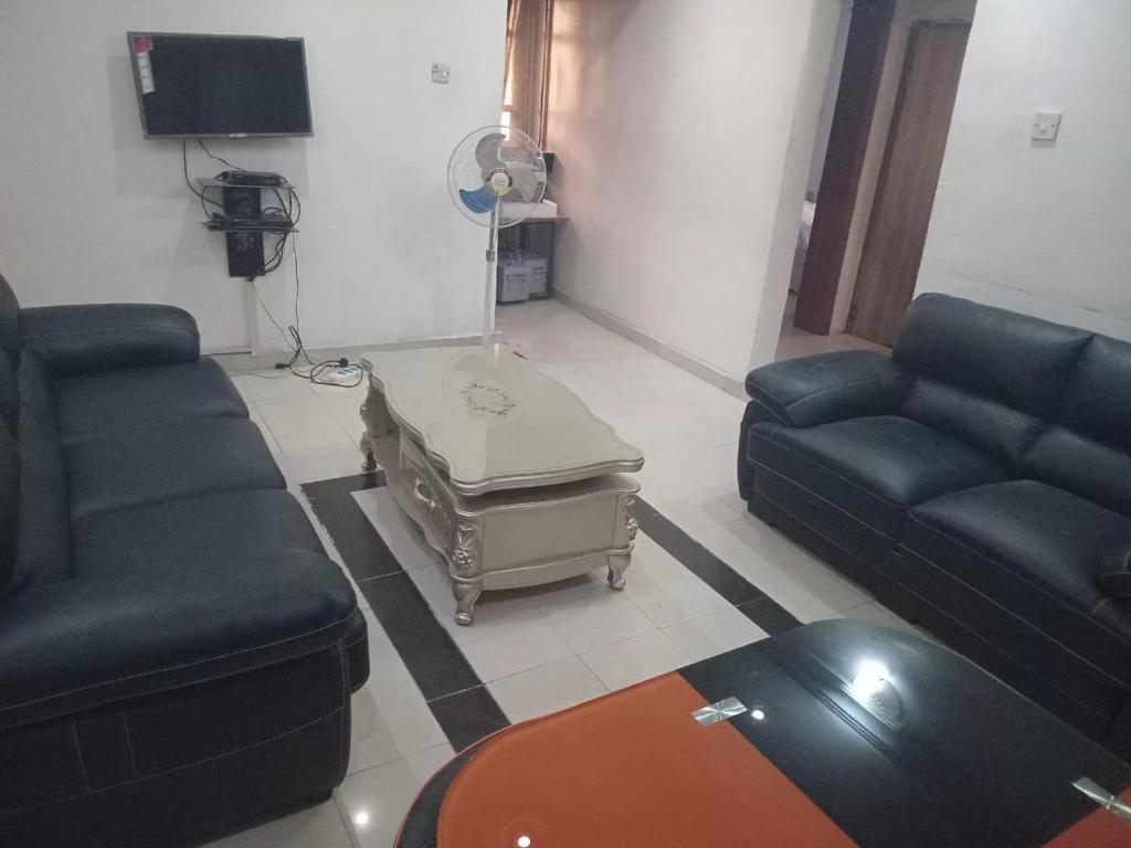 a living room with two couches and a table at Kadosh Homes - 2Bed Apartment in Magboro