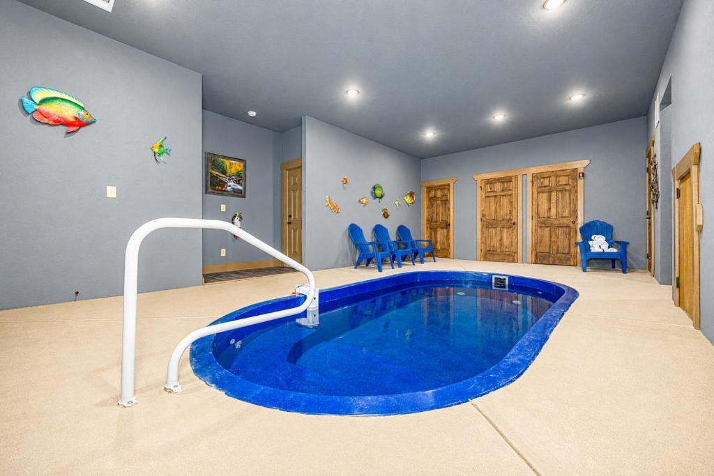 a home with a pool in a room with blue walls at Poolside Paradise - Luxe 4BR Chalet with Indoor Pool, Theater and Game Room in Gatlinburg