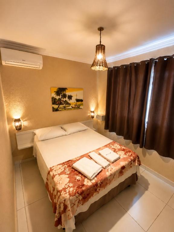 a bedroom with a bed with towels on it at Maré Praia Hotel in Fortaleza