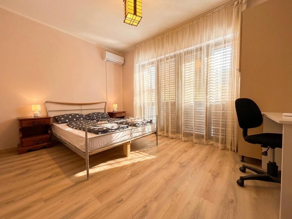 a bedroom with a bed and a desk and a window at D&D rooms 20 in Pula