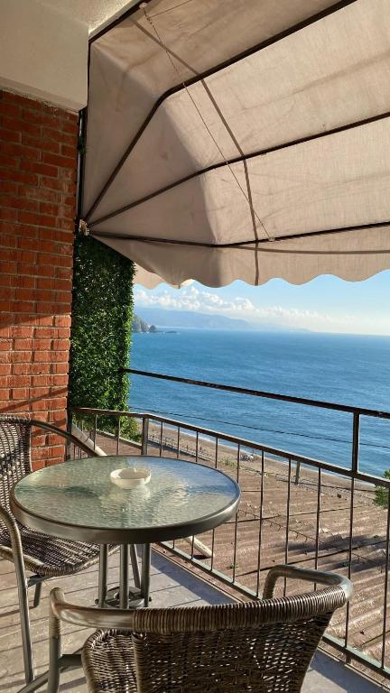 Ein Tisch und Stühle auf einem Balkon mit Meerblick in der Unterkunft Hisar Beach Hotel in Yaylacık