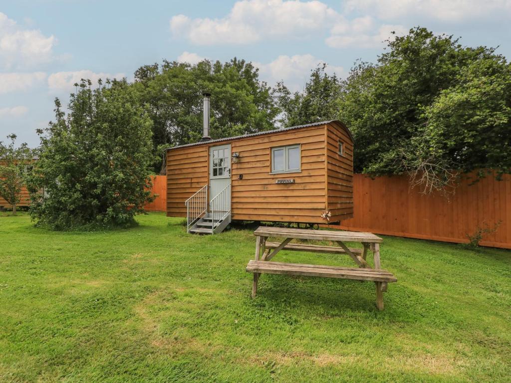 a wooden cabin with a picnic table in front of it at Pippins in Taunton