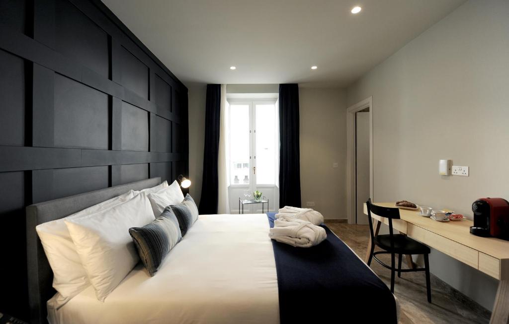 een slaapkamer met een groot bed met een zwart hoofdeinde bij The Manoel Boutique Hotel in Valletta