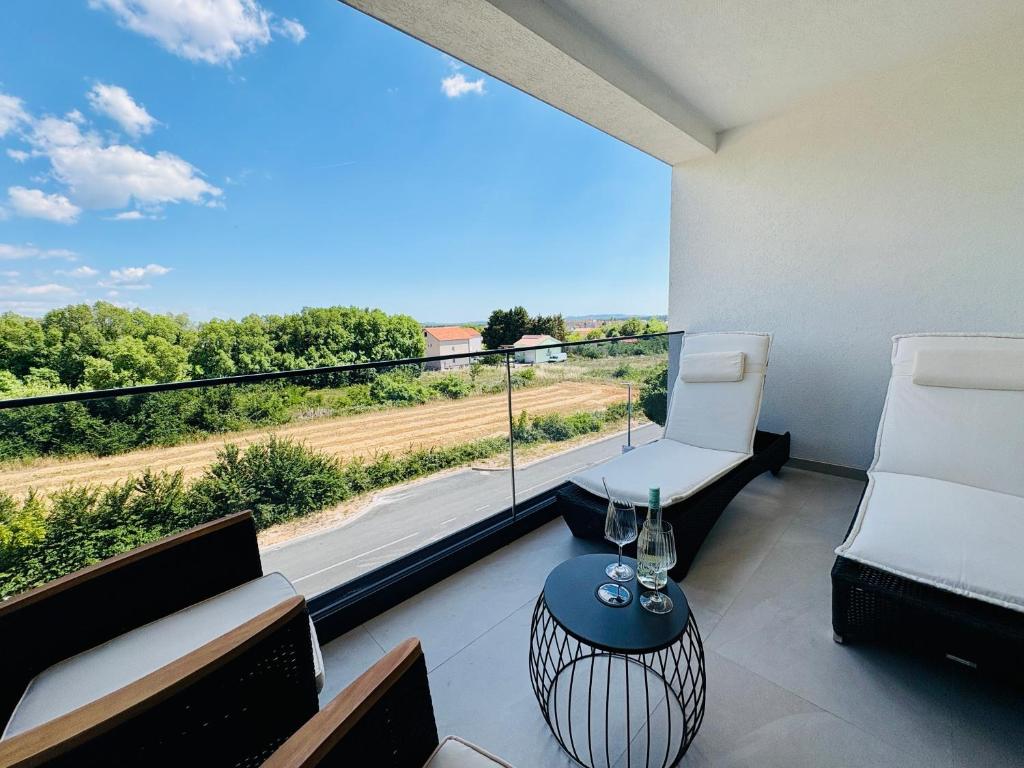 ein Balkon mit zwei Stühlen und einem großen Fenster mit Aussicht in der Unterkunft Vale in Benkovac