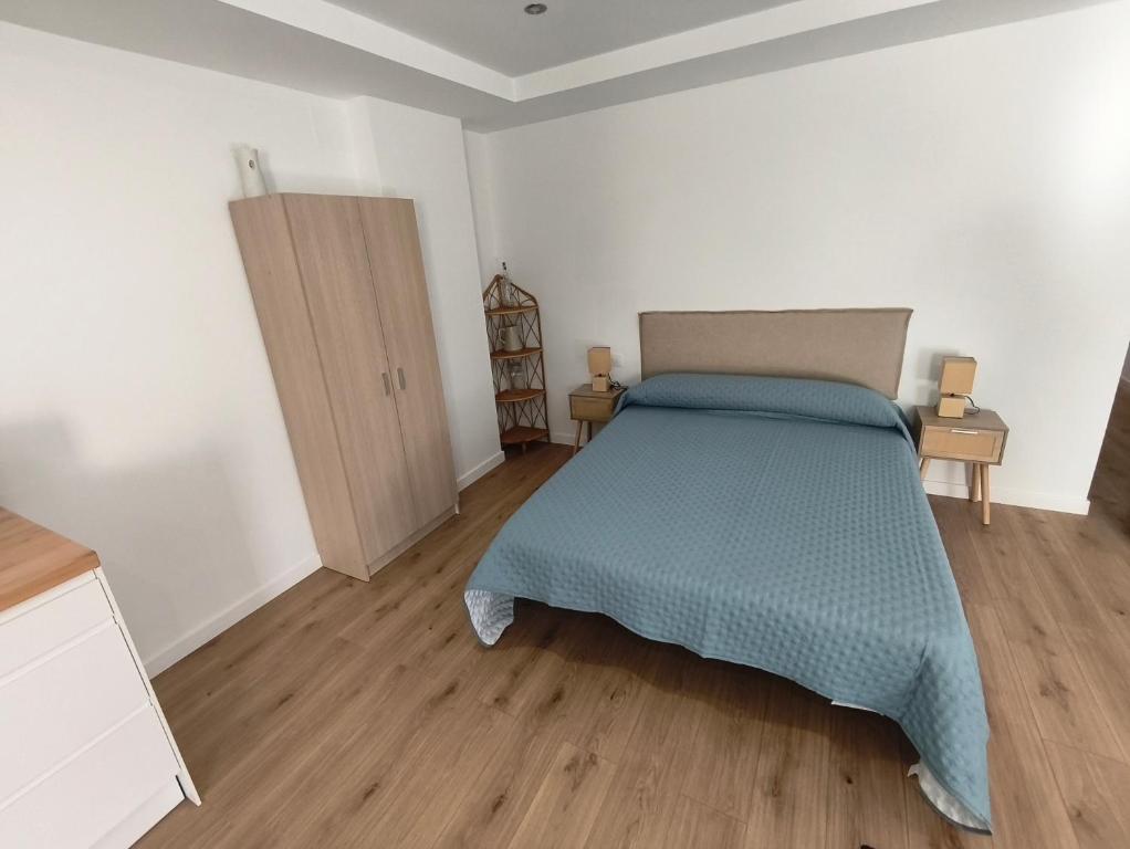 a bedroom with a bed and a wooden floor at Xeliña B in A Estrada