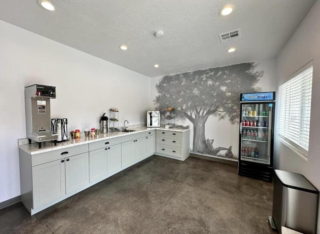 a kitchen with a tree mural on the wall at Shady Motel in Caliente