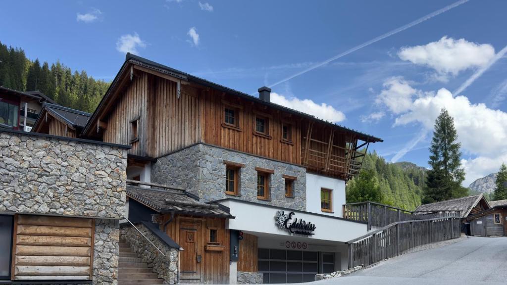 a large wooden house in the mountains at FIRSTpeak Chalets in Zauchensee