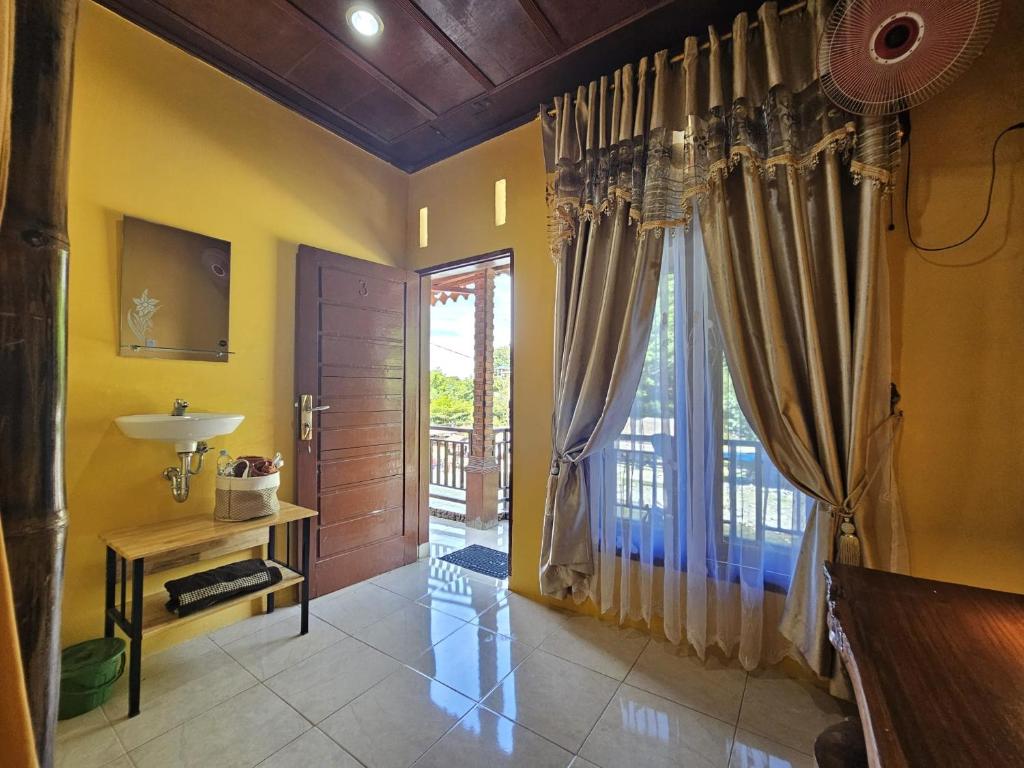 a bathroom with yellow walls and a sliding glass door at Sumatra Inn & Travel in Bukit Lawang