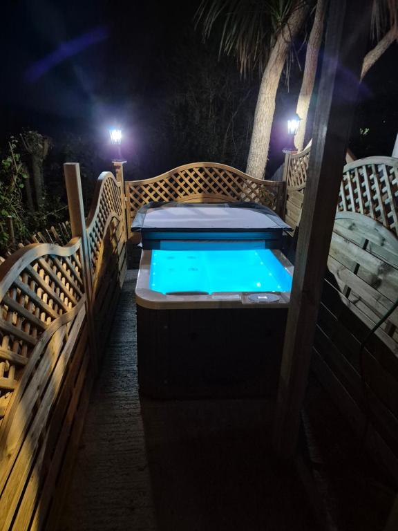 a jacuzzi tub with a wooden fence and lights at Seascape Spa Retreat in Niton