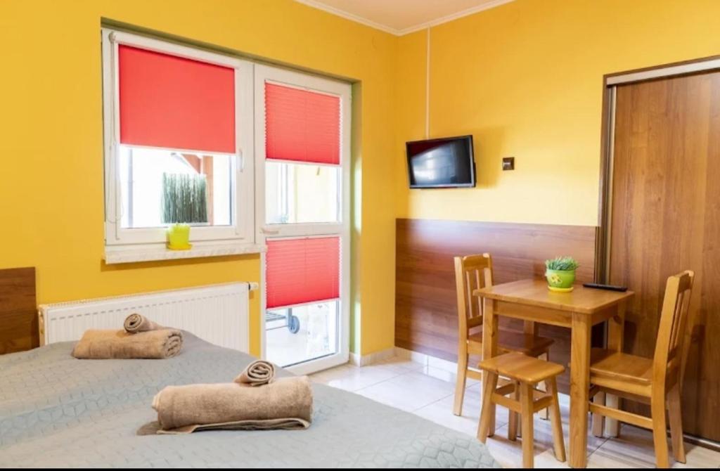 a bedroom with a bed and a table with a chair at Pokoje Mirów1A in Mirów