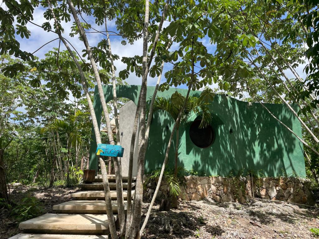 a building with stairs and a green wall at Selva Morena in Felipe Carrillo Puerto