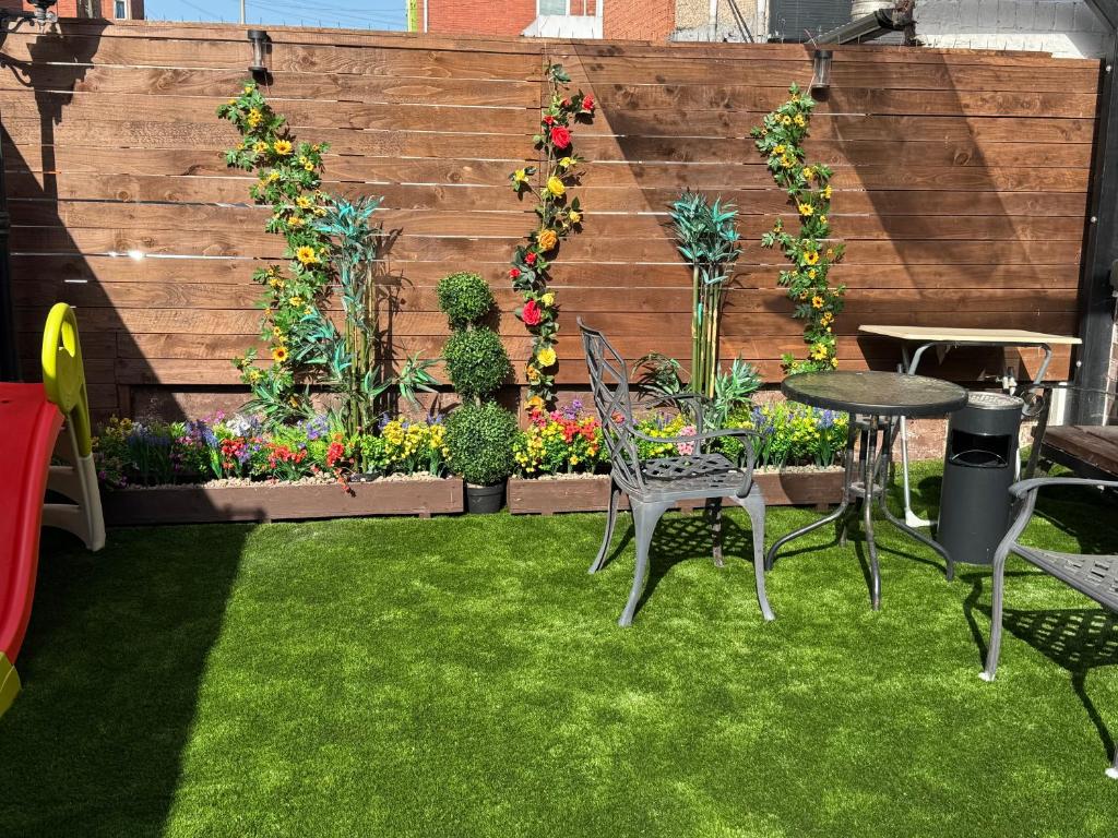a garden with a table and chairs and flowers at Blackpool cosy cottage in Blackpool