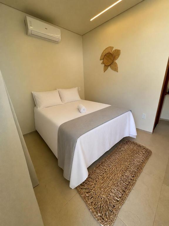 a bedroom with a white bed and a fan at Casa Dona Amélia in Barreirinhas