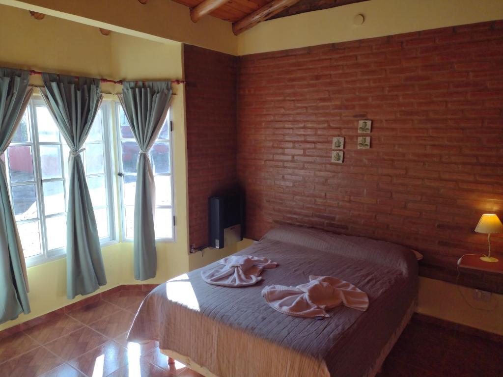 a bedroom with a bed with a brick wall at Cabañas Mi Atardecer in Nono