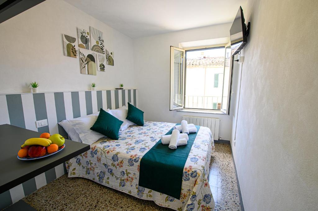 a bedroom with a bed with a bowl of fruit on it at Dimora l'Arancio in Lucca