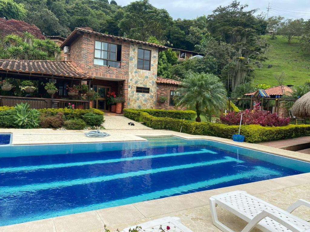 a swimming pool in front of a house at Finca Los Pony Girardota Antioquia in Girardota